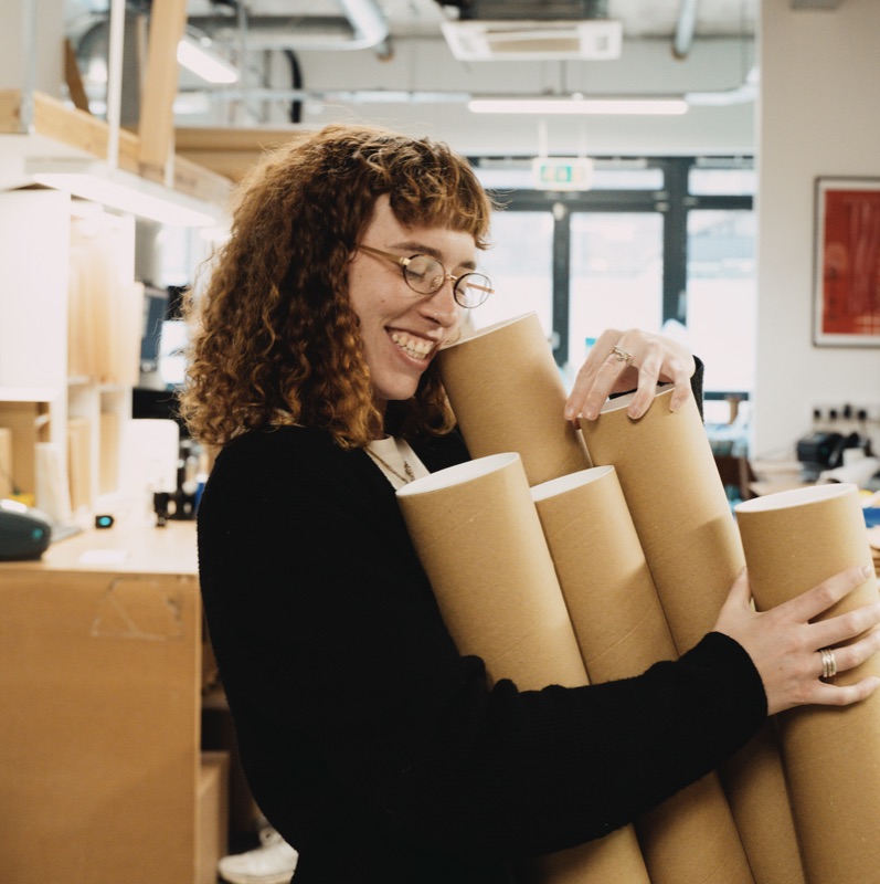 Team member carrying print tubes in the theprintspace studio